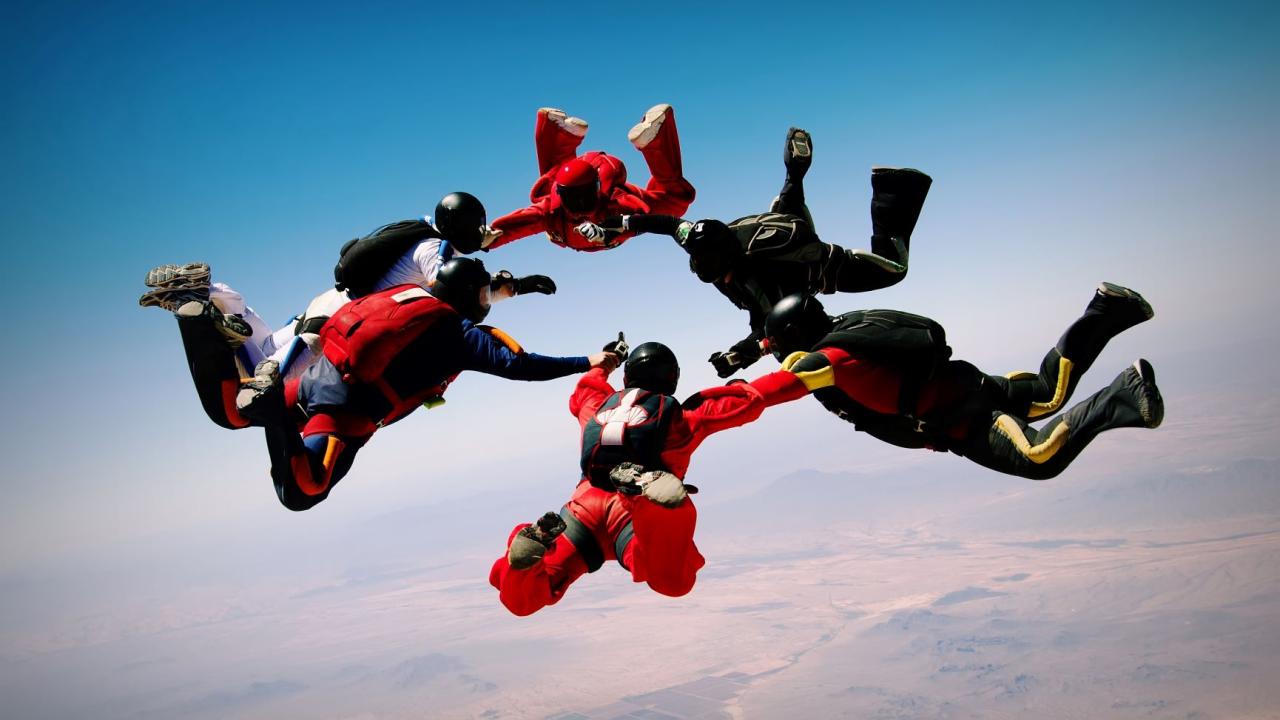 How Can We Build Team Trust? Parachuters forming a circle of team work