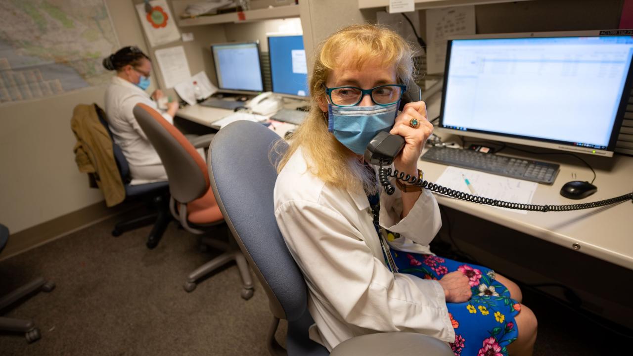 Doctor talking on phone in front of computer